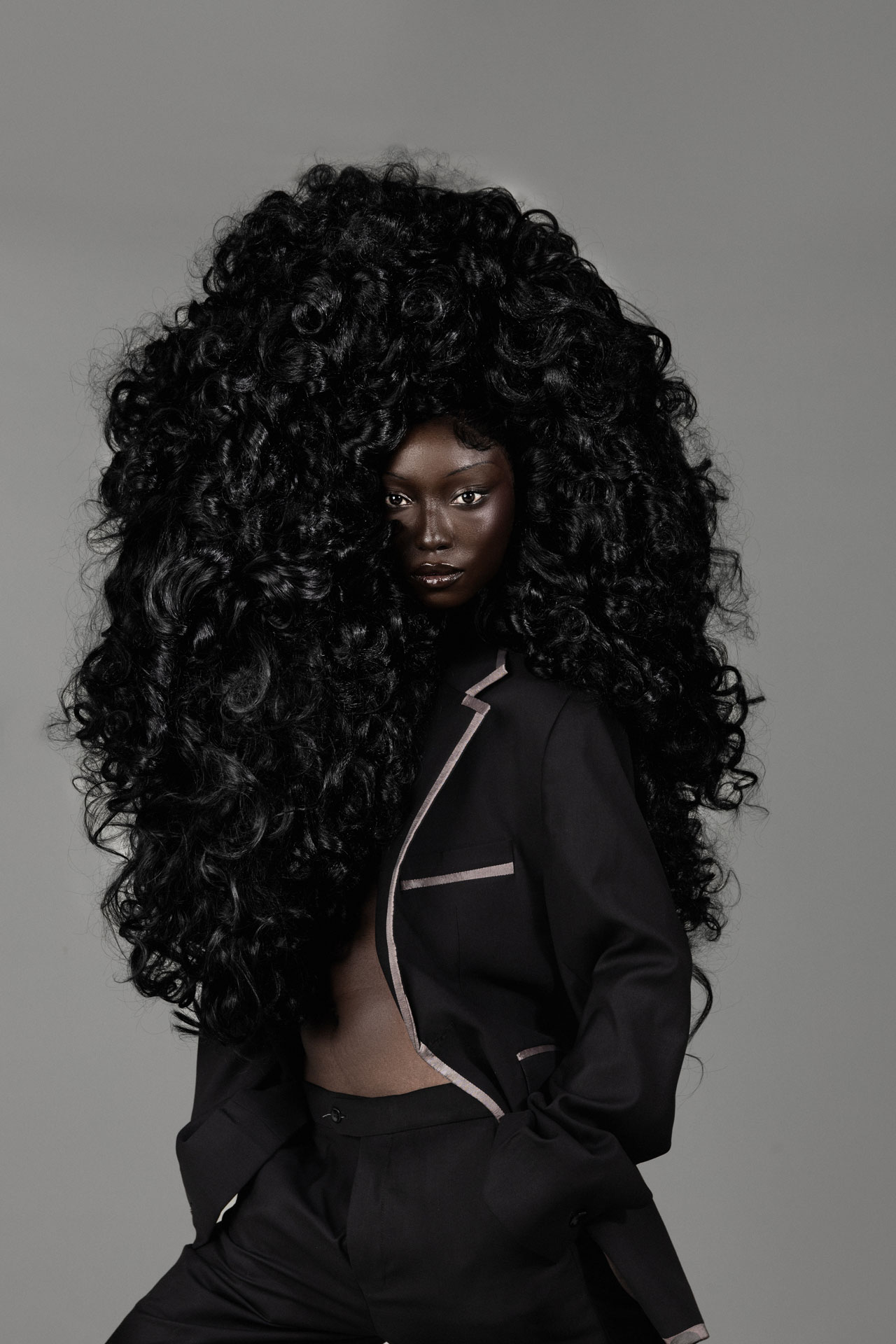 Three-quarter portrait in black tailoring with voluminous curls