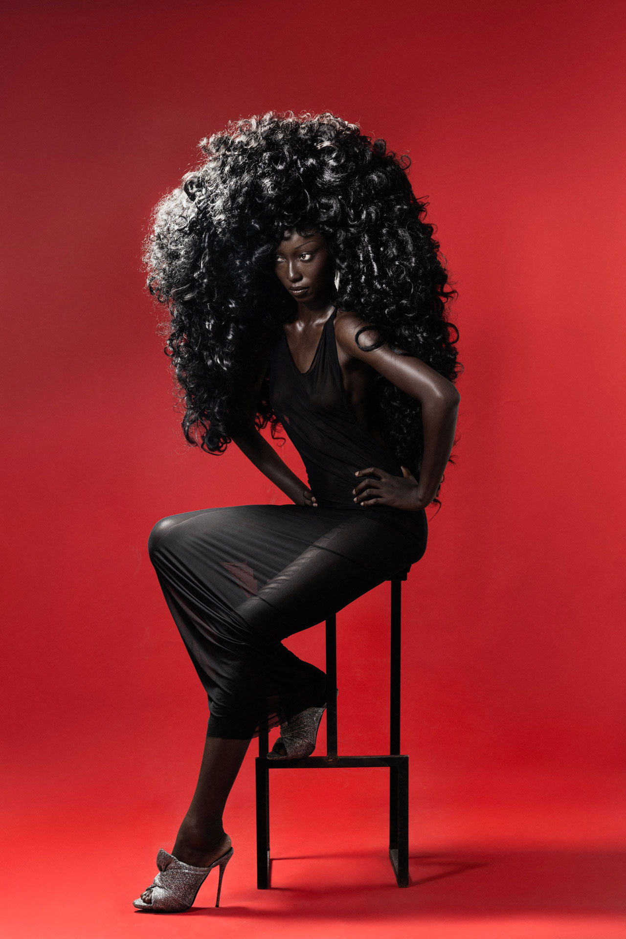 Seated portrait on a chair against red