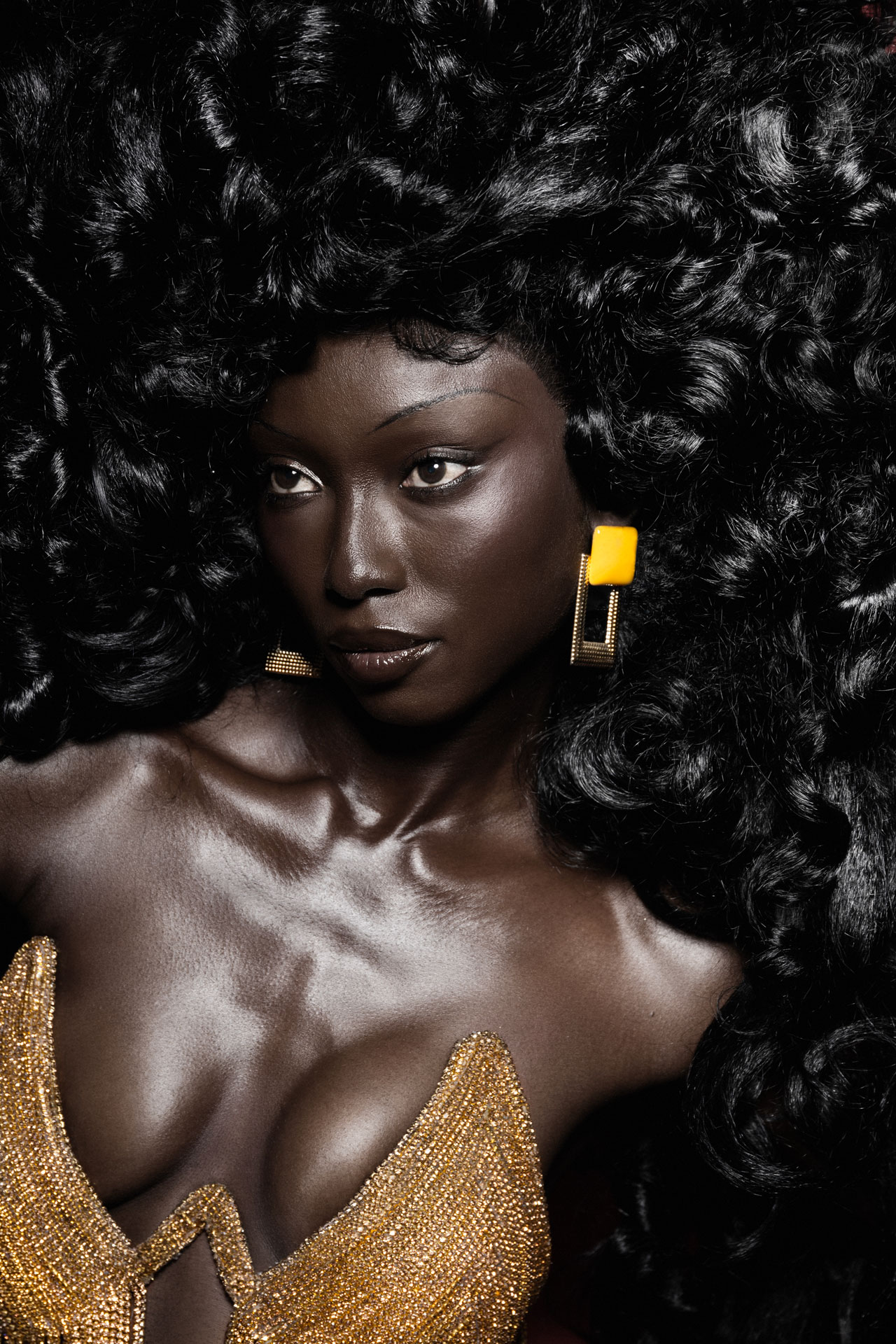 Close gold-fringe portrait with geometric earrings