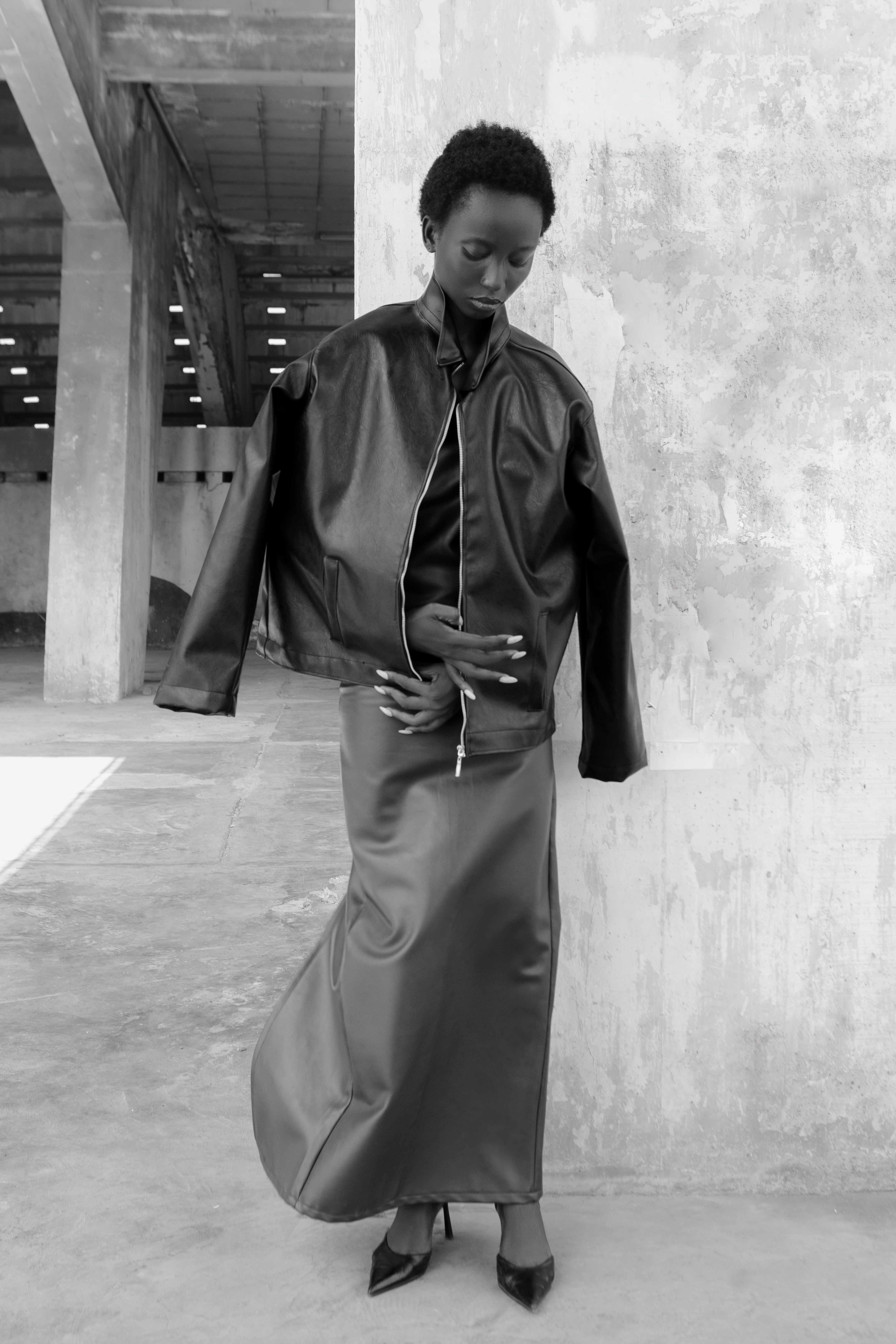 Full-length black-and-white portrait looking down at the coat