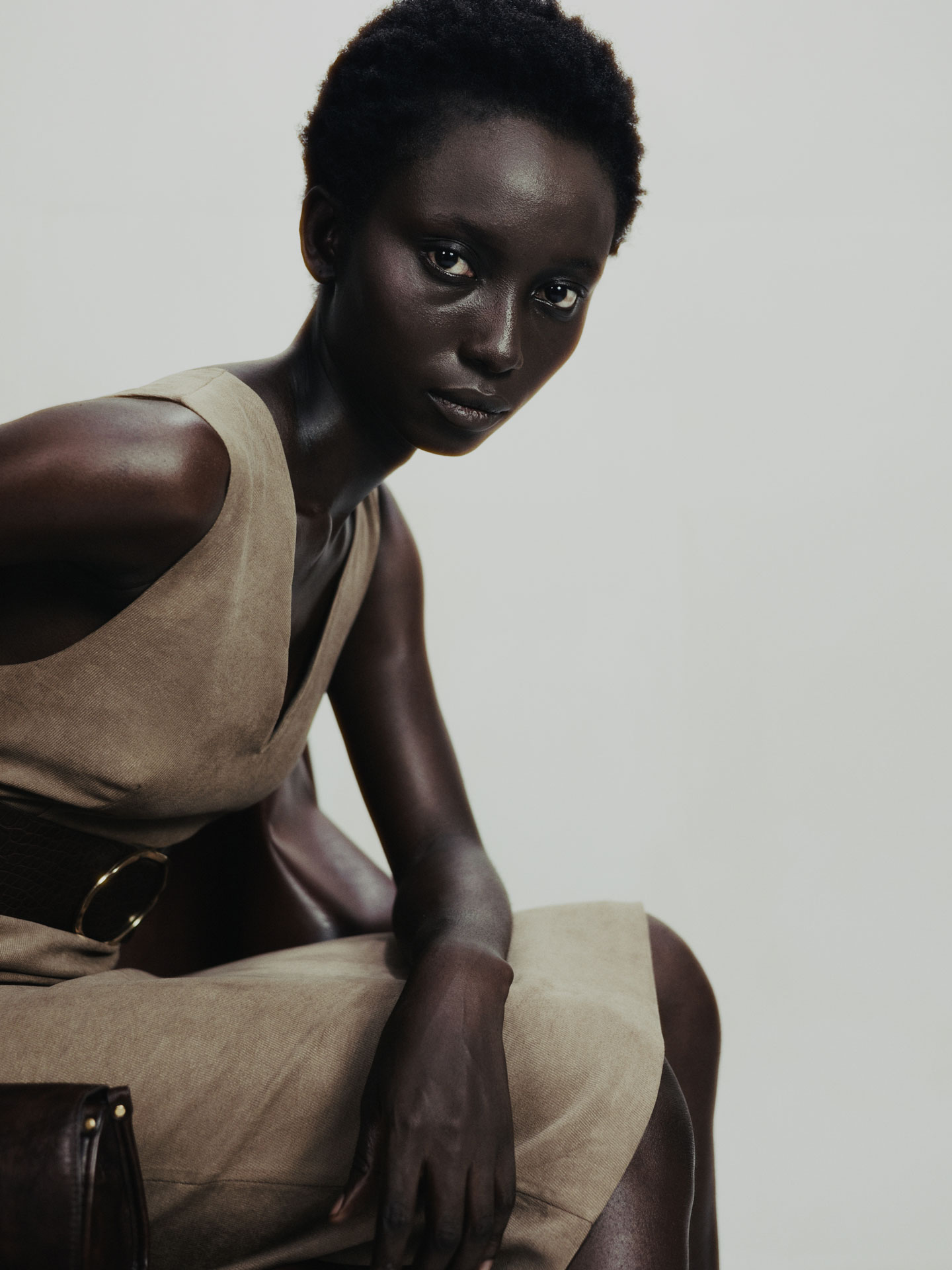 Closer seated studio test in taupe layers with dark leather at the side